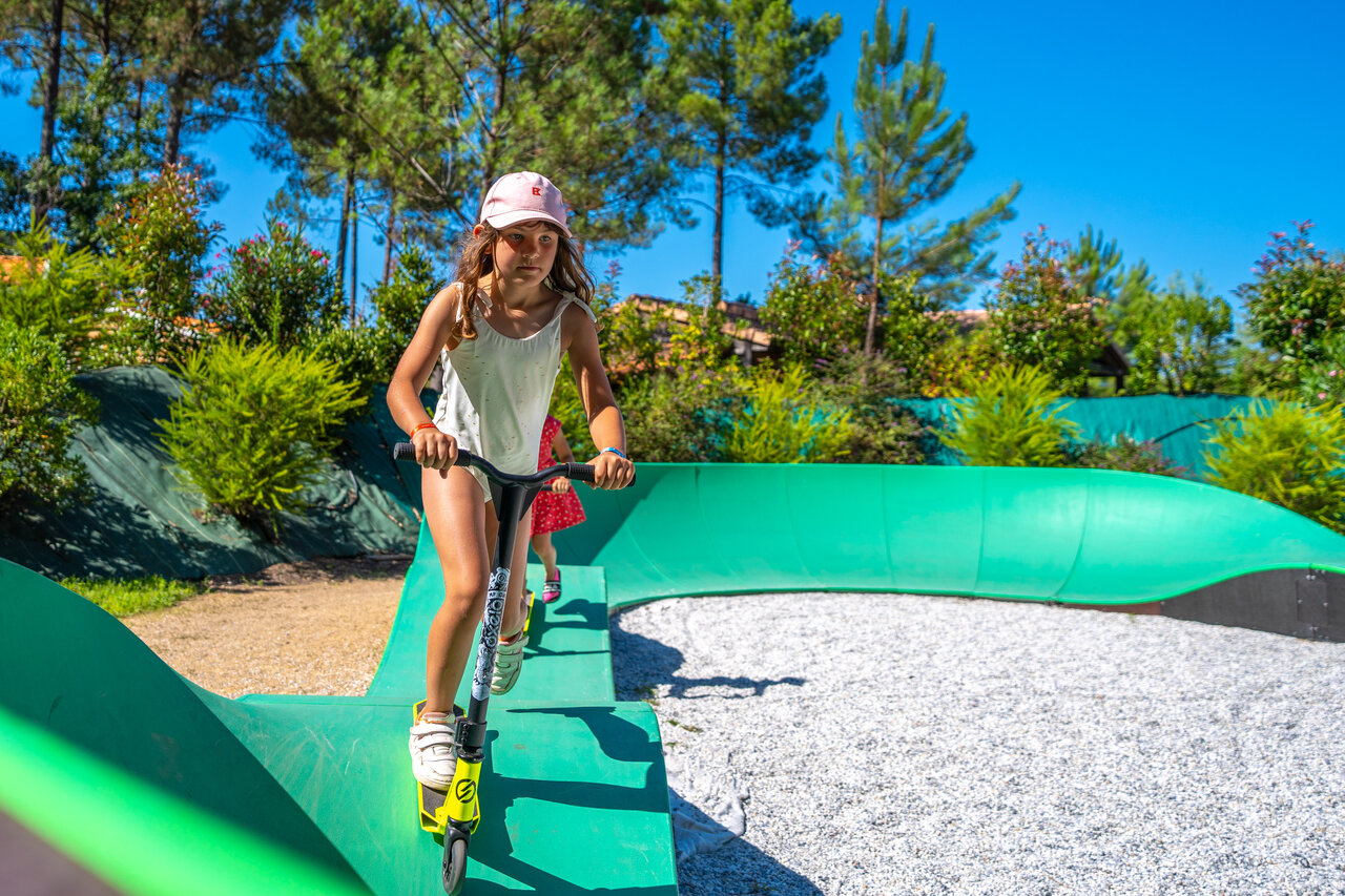 Kind op step op groene pumptrack bij camping CAPFUN Huttes in Saint-Denis d'Ol�ron.
