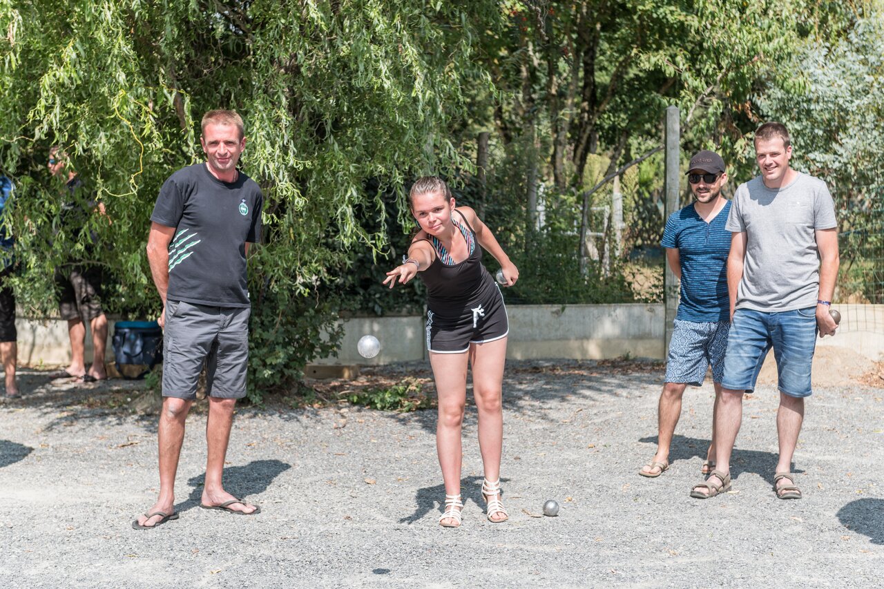Jongeren en volwassenen spelen jeu de boules op een baan, op camping CAPFUN Huttes in Saint-Denis d'Ol�ron (17).
