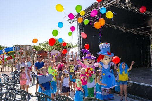 Kinderen en mascottes laten kleurrijke ballonnen los tijdens animatie op camping CAPFUN Huttes in Saint-Denis d'Ol�ron (17).