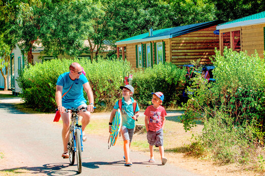 Familie op fiets en stacaravans bij camping CAPFUN Huttes in Saint-Denis d'Ol�ron.