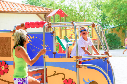 Lachend kind en vrouw op speeltuin op camping CAPFUN Huttes in Saint-Denis d'Ol�ron.