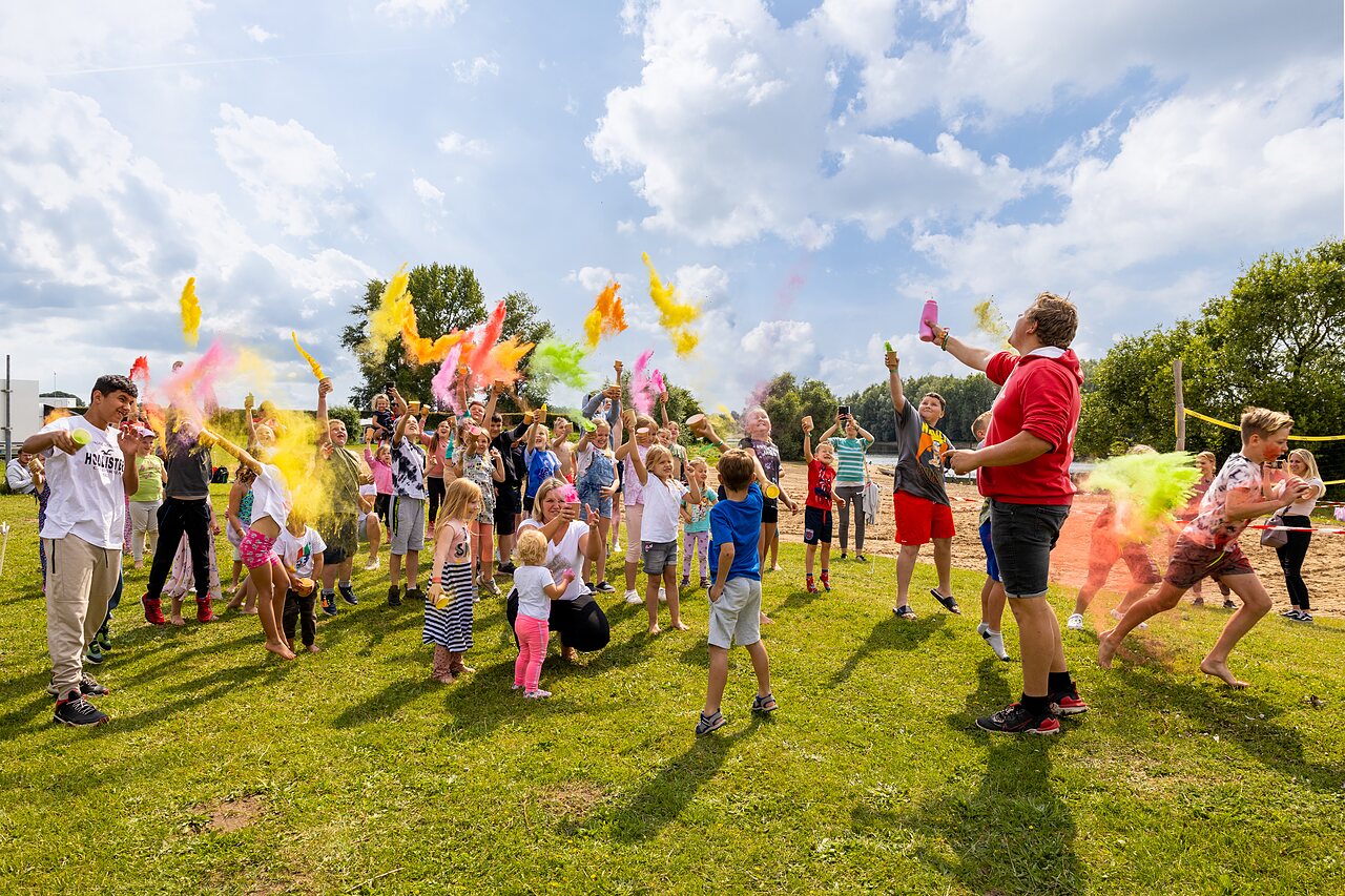 Kinderen en volwassenen genieten van kleurenpoeder animatie op camping CAPFUN IJsselstrand in Doesburg.