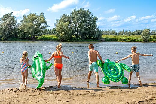 Kinderen op het strand, opblaasbare drijvers, op camping CAPFUN IJsselstrand in Doesburg.