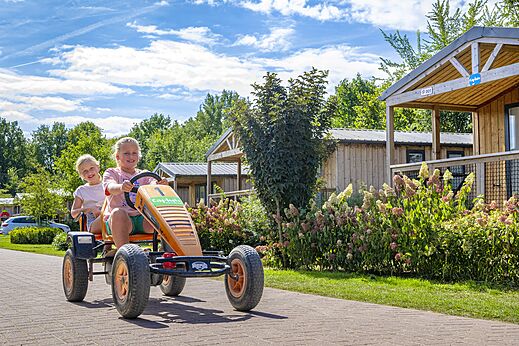 Lachende kinderen op een skelter op camping CAPFUN IJsselstrand in Doesburg.