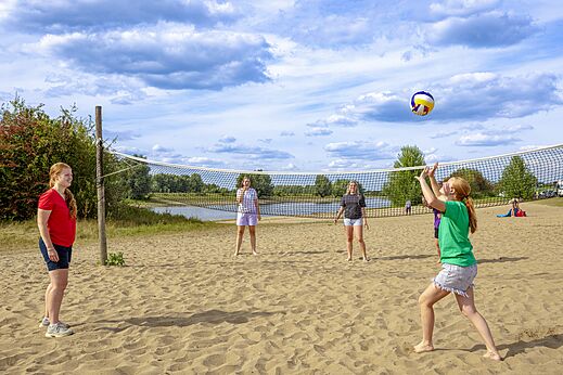 Volleyballers op het zandstrand bij camping CAPFUN IJsselstrand in Doesburg.