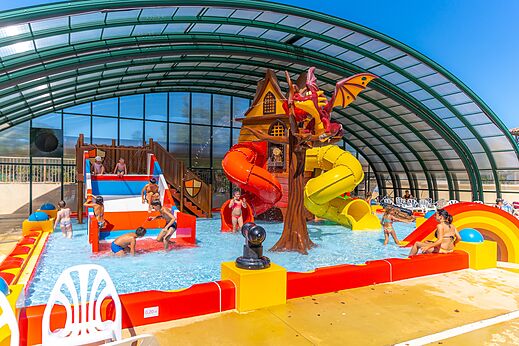 Overdekte waterspeeltuin met glijbanen en draak op camping CAPFUN Imbours in LARNAS (07).