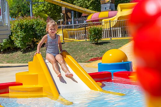Klein meisje op waterglijbaan op camping CAPFUN Imbours in LARNAS (07).