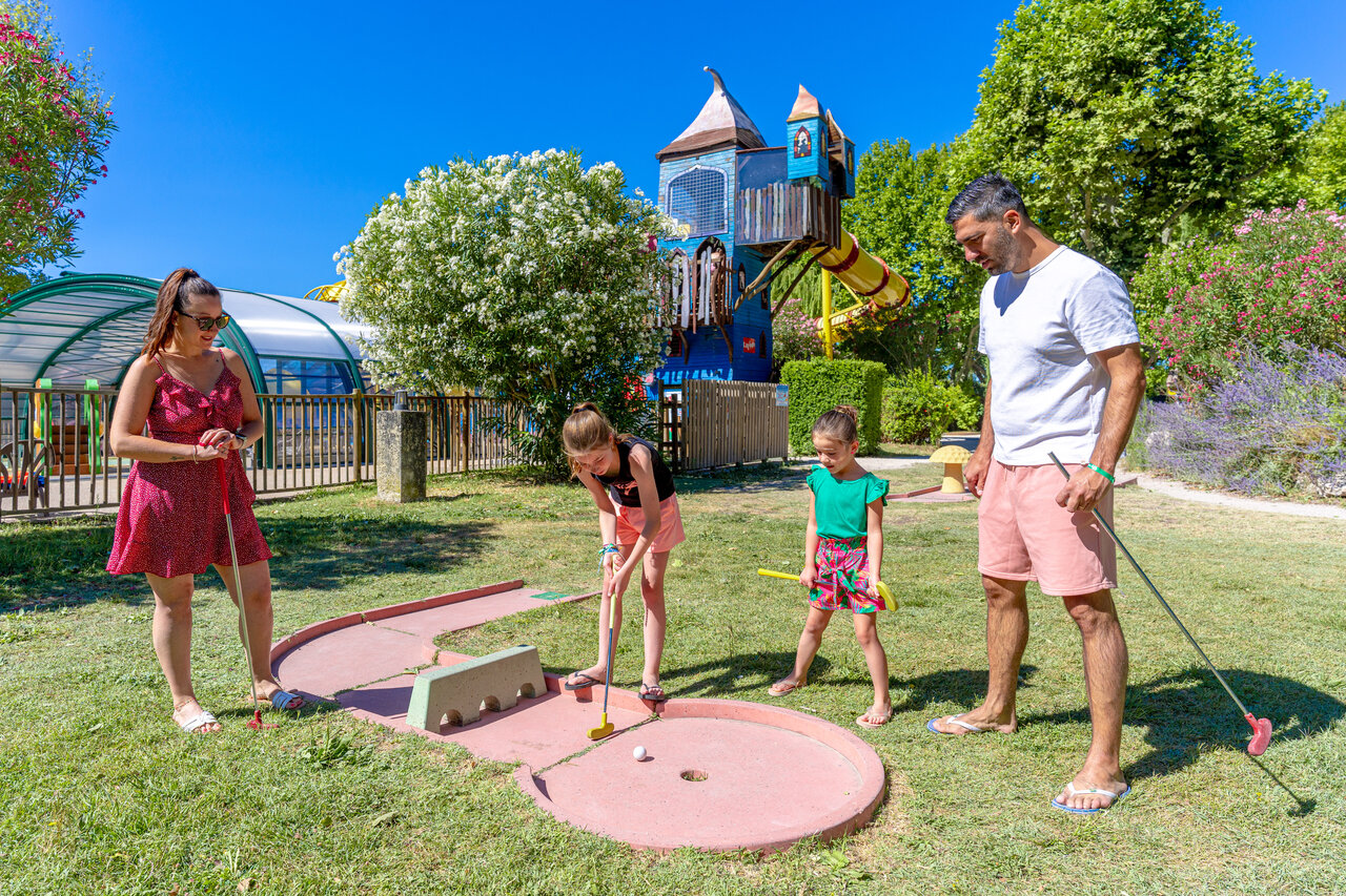 Familie speelt minigolf met speeltuin en zwembad op camping CAPFUN Jantou in LE THOR (84).