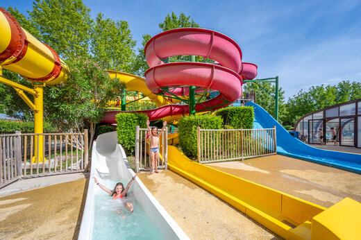 Kinderen vermaken zich op kleurrijke waterglijbanen op camping CAPFUN Jantou in LE THOR (84).