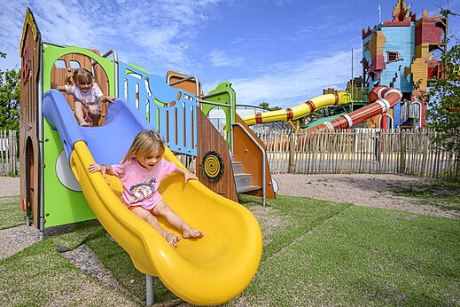 Kinderen op kleurrijke glijbanen, speeltuin van camping CAPFUN Joncal.