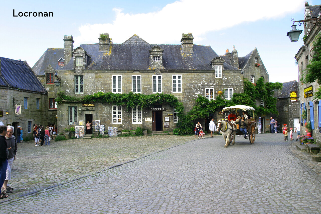 Historisch geplaveid plein in Locronan, Bretagne, met koets en cr�perie.
