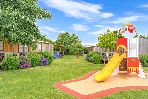 Speeltuin met glijbaan en stacaravans op camping CAPFUN Kervel in PLONEVEZ PORZAY (29).
