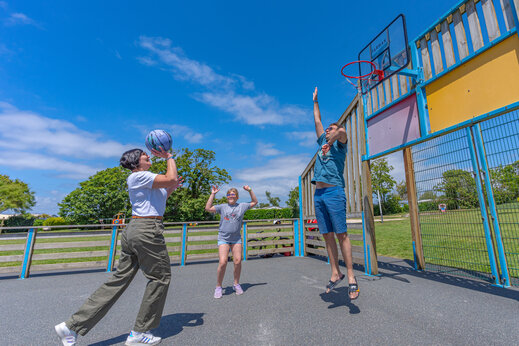 Familie speelt basketbal op het multisportterrein op camping CAPFUN Kervel in PLONEVEZ PORZAY (29).