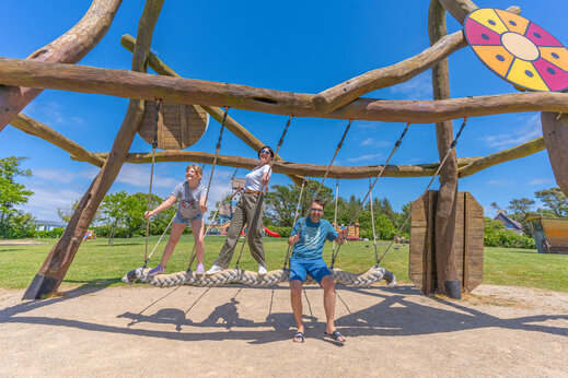 Grote houten touwschommel op de speeltuin van camping CAPFUN Kervel.