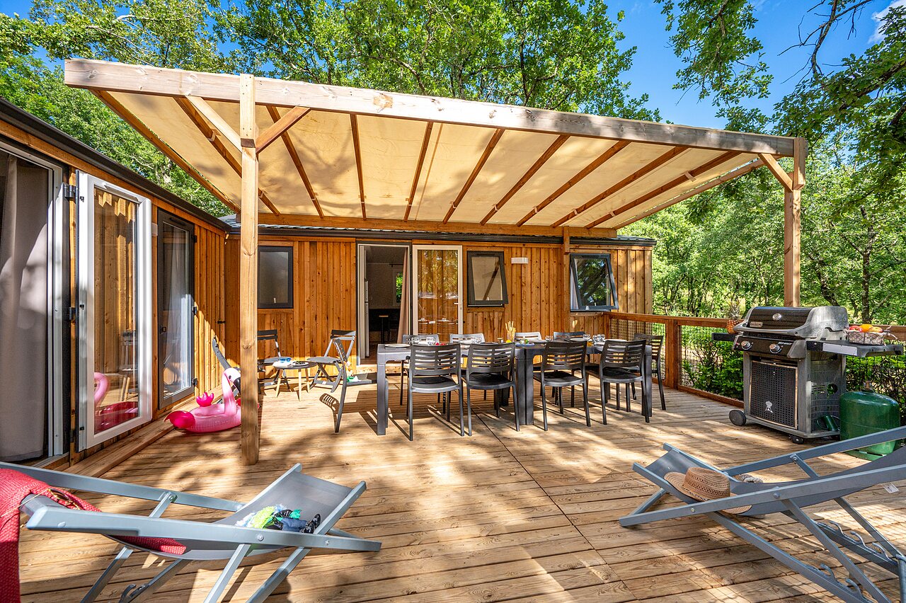 Ruim overdekt terras, barbecue en stacaravan op camping VAGUES OCEANES Labeiller in Saint Victor de Malcap (30).