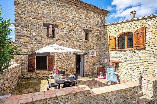 Stenen accommodatie met terras en tafel op camping VAGUES OCEANES Labeiller in Saint Victor de Malcap (30).