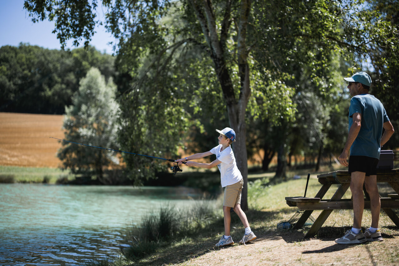 Kind vist in het meer met een volwassene op camping CAPFUN Lac des 3 Vall�es.