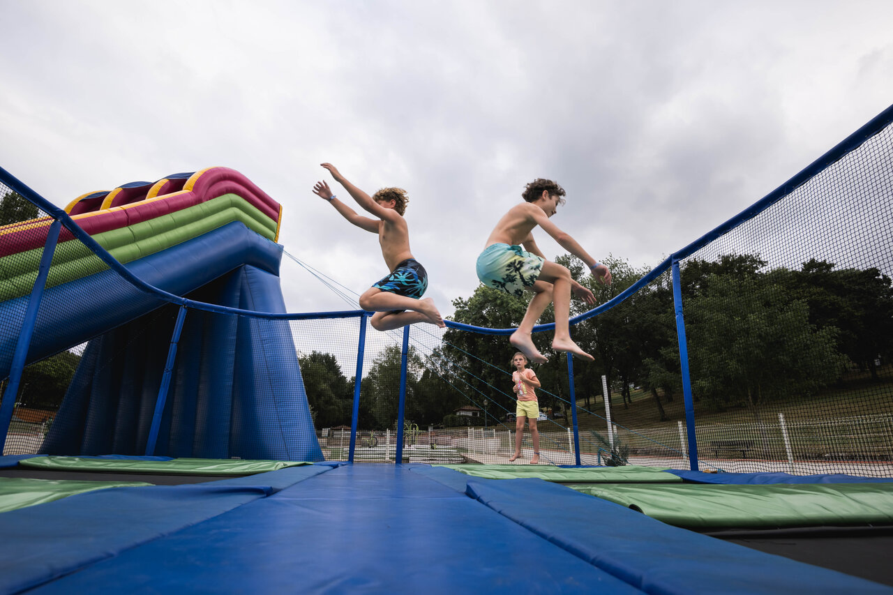 Kinderen springen op trampoline en opblaasbare spelen bij CAPFUN Lac des 3 Vall�es, Lectoure.