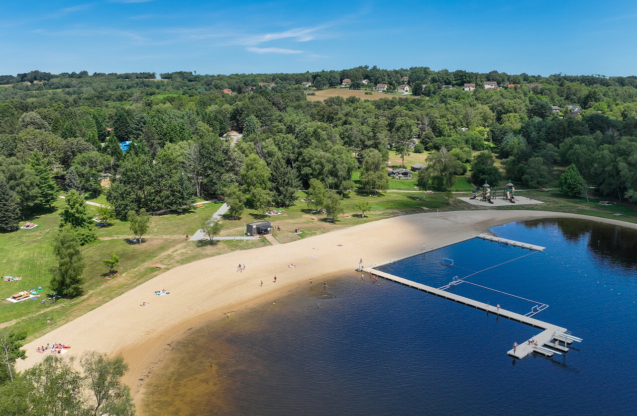 Zandstrand, drijvende steiger en wateractiviteiten op camping CLICOCHIC Lac de Miel in Beynat (19).