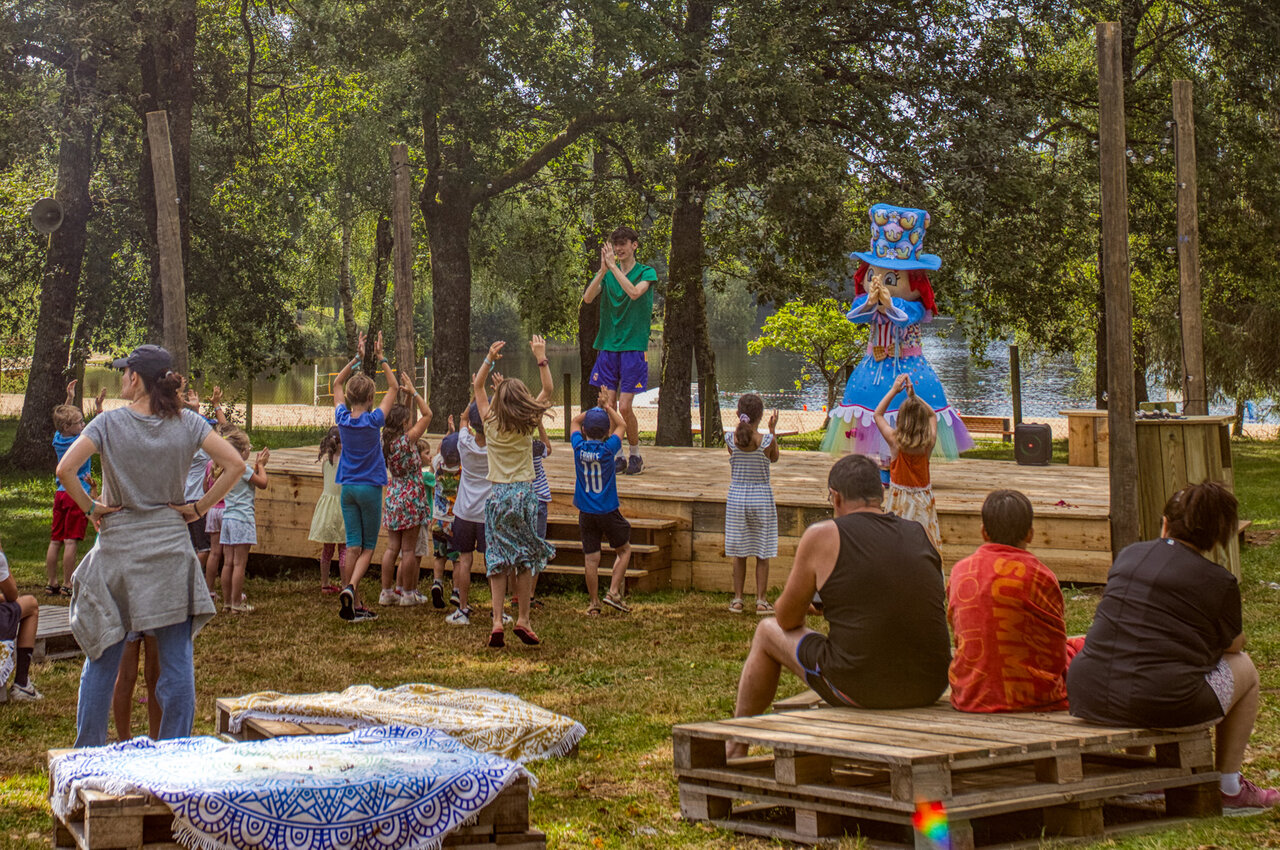Kinderanimatie met animator en mascotte op podium op camping CLICOCHIC Lac de Miel in Beynat (19).
