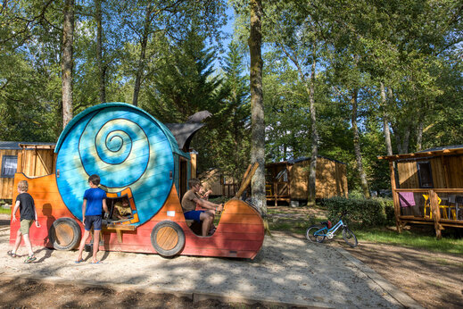 Kinderen spelen op slak speeltoestel, Mobil-homes op camping CLICOCHIC Lac de Miel in Beynat (19).
