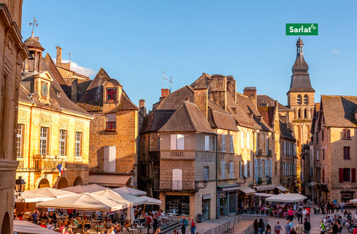 Levendig historisch plein met restaurantterrassen in Sarlat, Dordogne.
