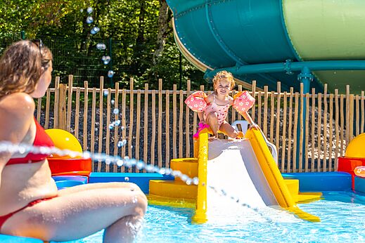 Kind op waterglijbaan, kinderbad op camping VAGUES OCEANES Lac de Panthier in Vandenesse-en-Auxois (21).