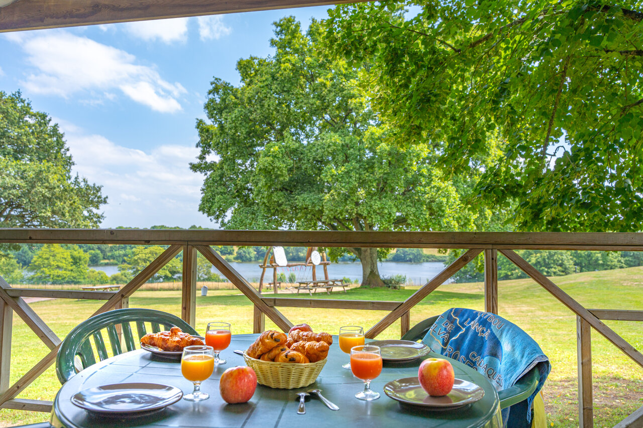 Ontbijt op terras accommodatie, uitzicht meer, bij CAPFUN Lac de Ribou in Cholet.