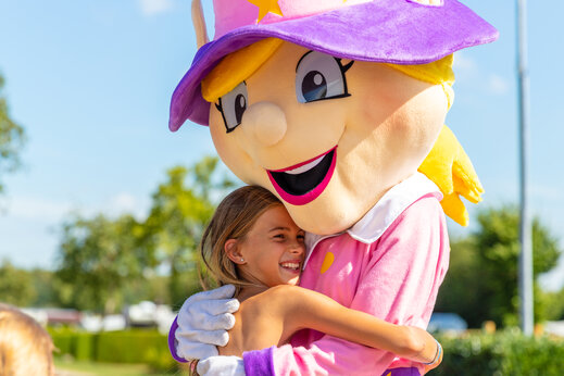Camping mascotte knuffelt een kind, animatie op CAPFUN Lac de Ribou in Cholet (49).