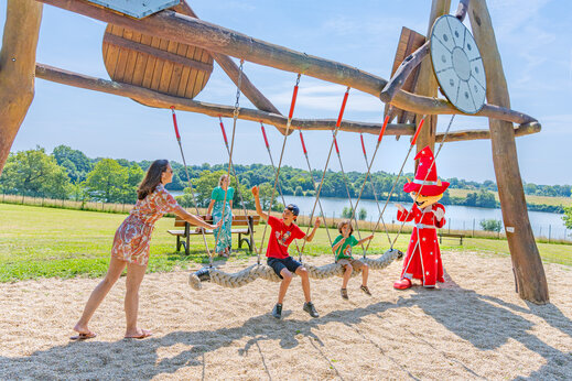 Kinderen en mascotte op reuzenschommel op camping CAPFUN Lac de Ribou in Cholet.