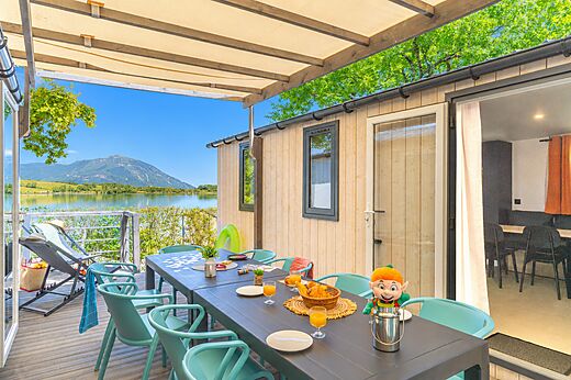 Stacaravan met terras, tafel, stoelen, uitzicht op het meer op camping CLICOCHIC Lac du Lit du Roi in Massignieu-de-Rives (01).