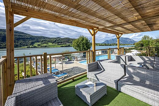 Buiten loungehoek, uitzicht meer en bergen op camping CLICOCHIC Massignieu-de-Rives