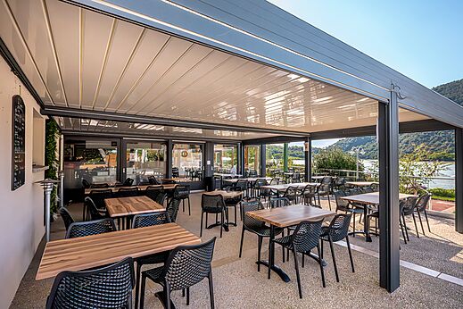 Buitenrestaurant terras met tafels en stoelen op camping CLICOCHIC Lac du Lit du Roi.