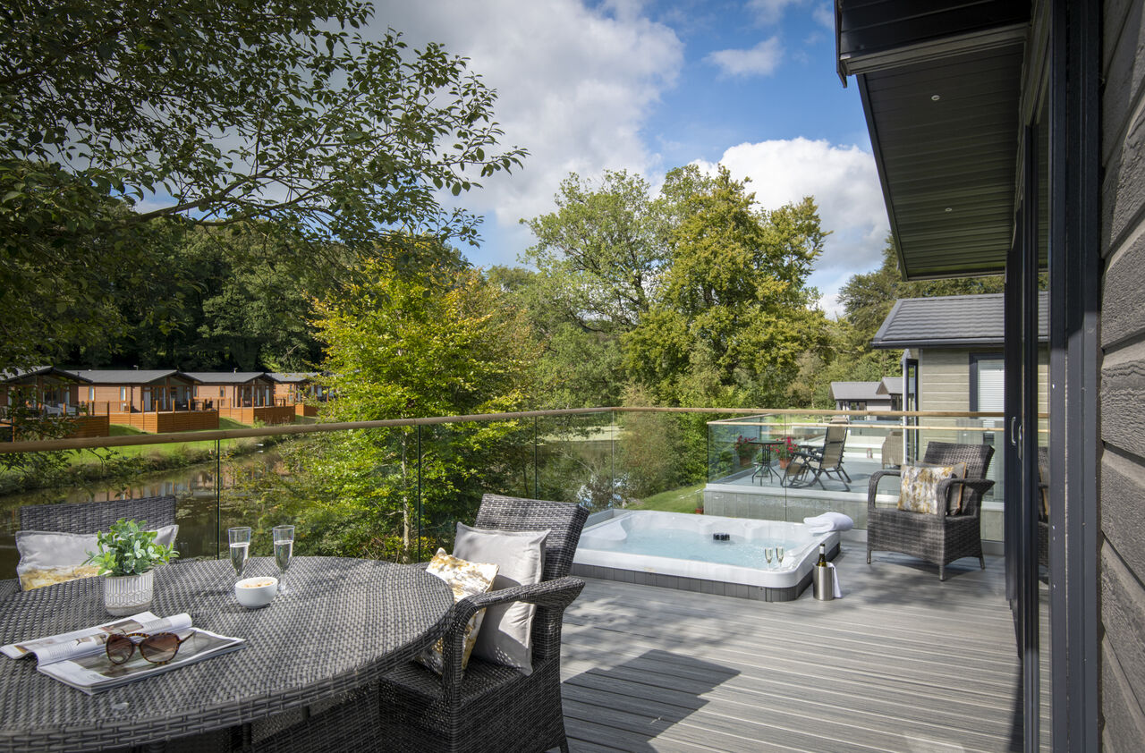 Terras met jacuzzi en houten chalets op CAPFUN UK Lakeview Manor, Dunkeswell.