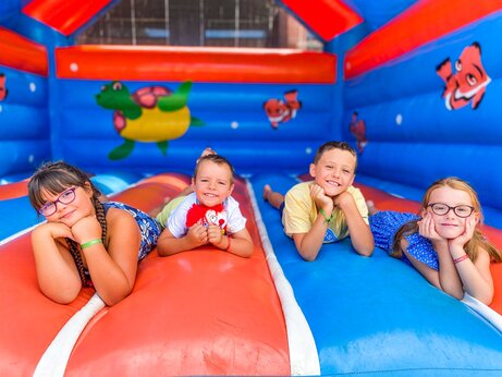 Lachende kinderen op kleurrijk opblaasbaar speeltoestel op camping CAPFUN Landisland in Moliets-et-Maa (40).