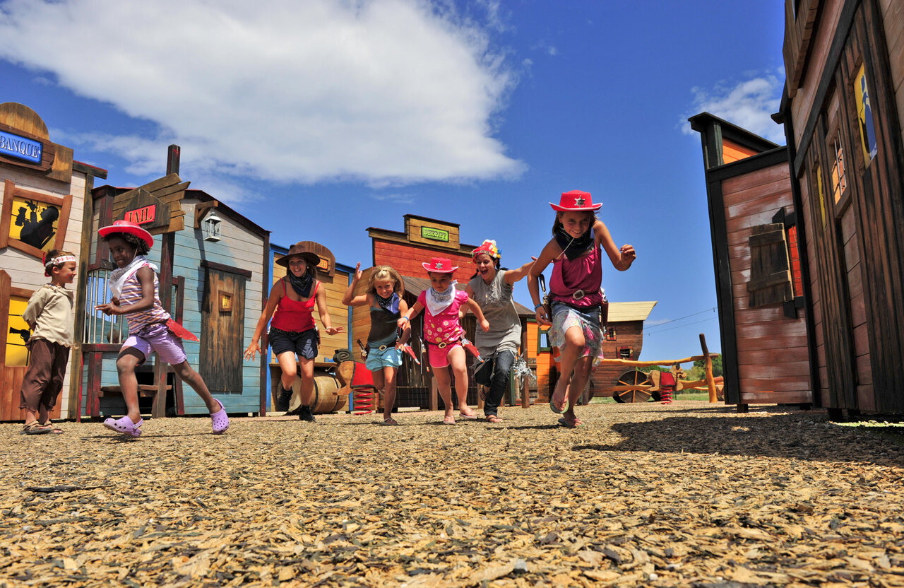 Kinderen verkleed als cowboys rennen in westernstad, animatie op camping CAPFUN Las Bousigues.