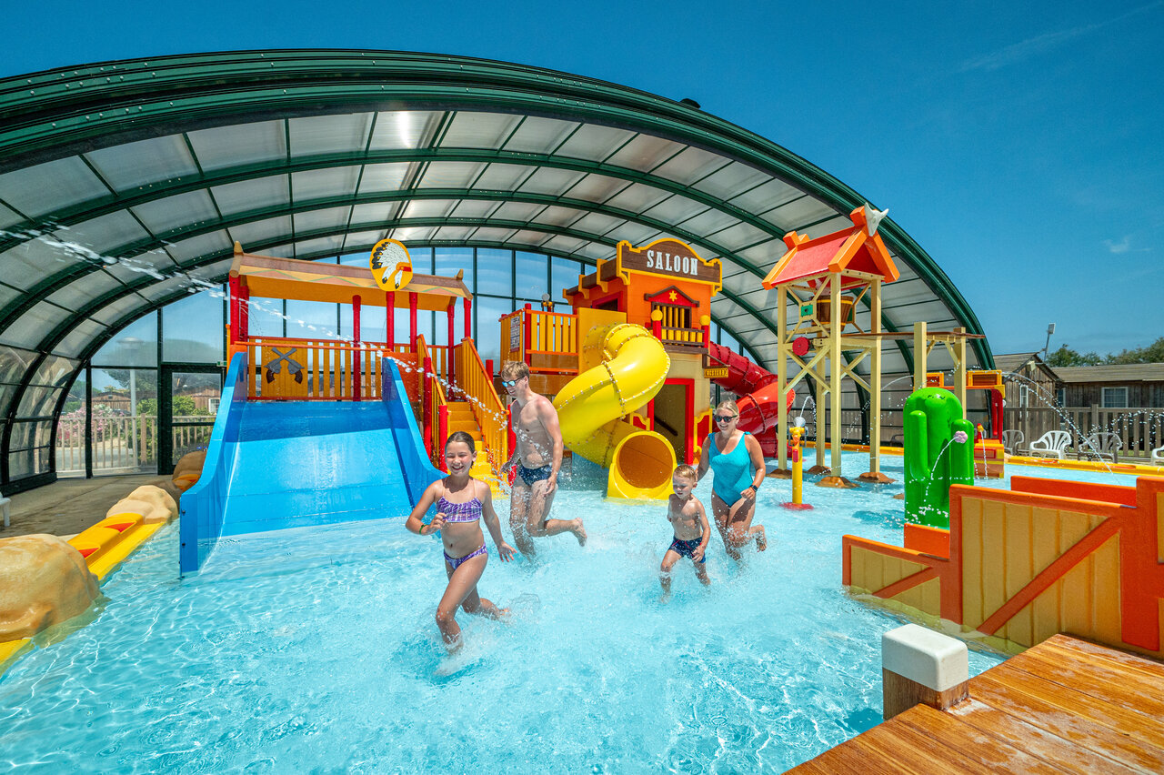 Familie vermaakt zich in overdekt waterpark op camping CAPFUN Las Bousigues.