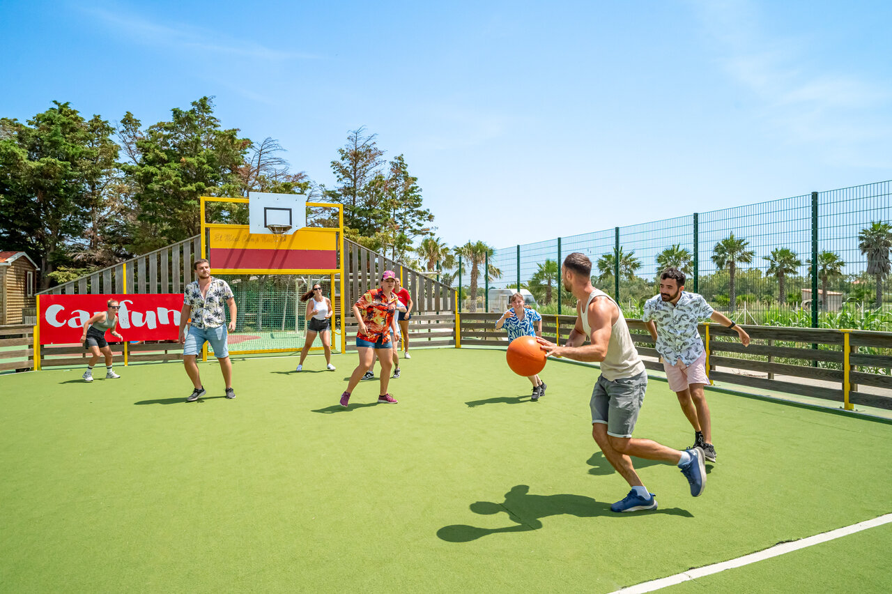 Multisportterrein met jongeren die basketballen op camping CAPFUN Las Bousigues in Le Barcar�s (66).