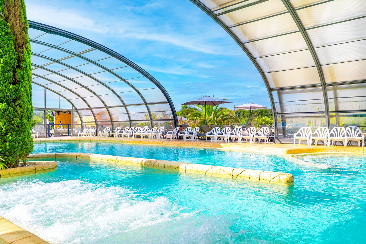 Overdekt zwembad, balneoruimte en ligstoelen op camping VAGUES OCEANES Les Iles.