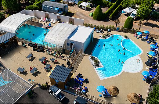 Buiten- en binnenbaden met zwemmers op camping CLICOCHIC Bellevue d'Erquy.