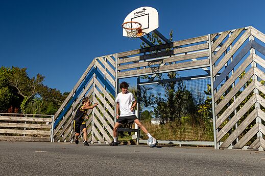 Multisportterrein met kinderen die voetballen op camping CLICOCHIC in Lannion.