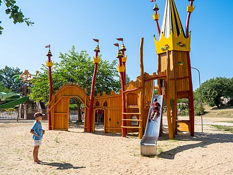 Houten kasteel speeltuin met glijbaan op camping CLICOCHIC in Padirac.