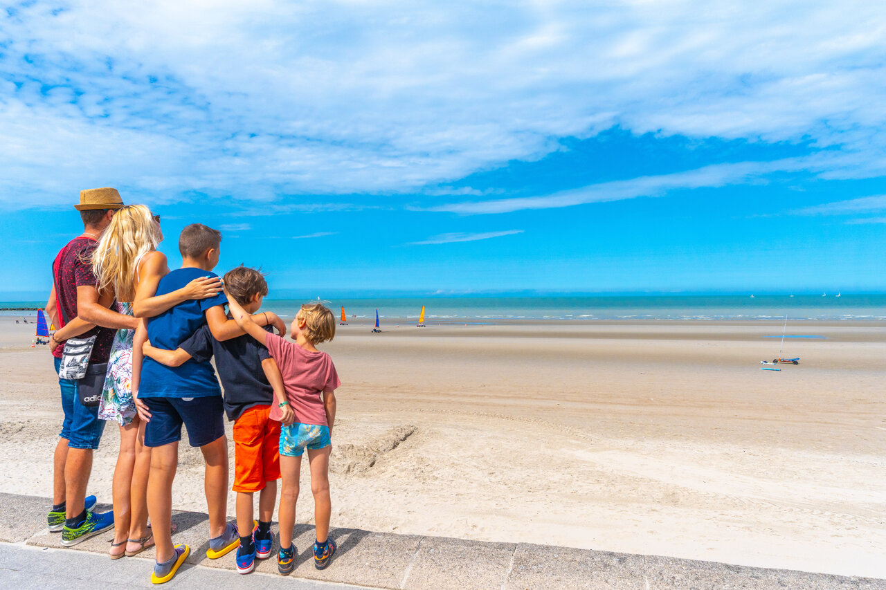 Familie kijkt naar strandzeilen op het strand bij camping VAGUES OCEANES Licorne in Duinkerke (59).