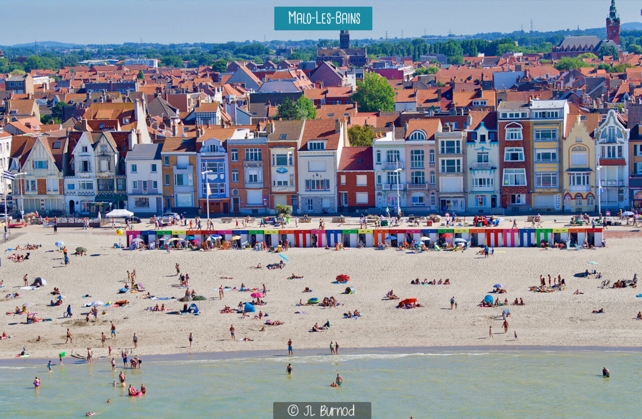 Strand van Malo-les-Bains met kleurrijke strandhuisjes en stad Duinkerke.