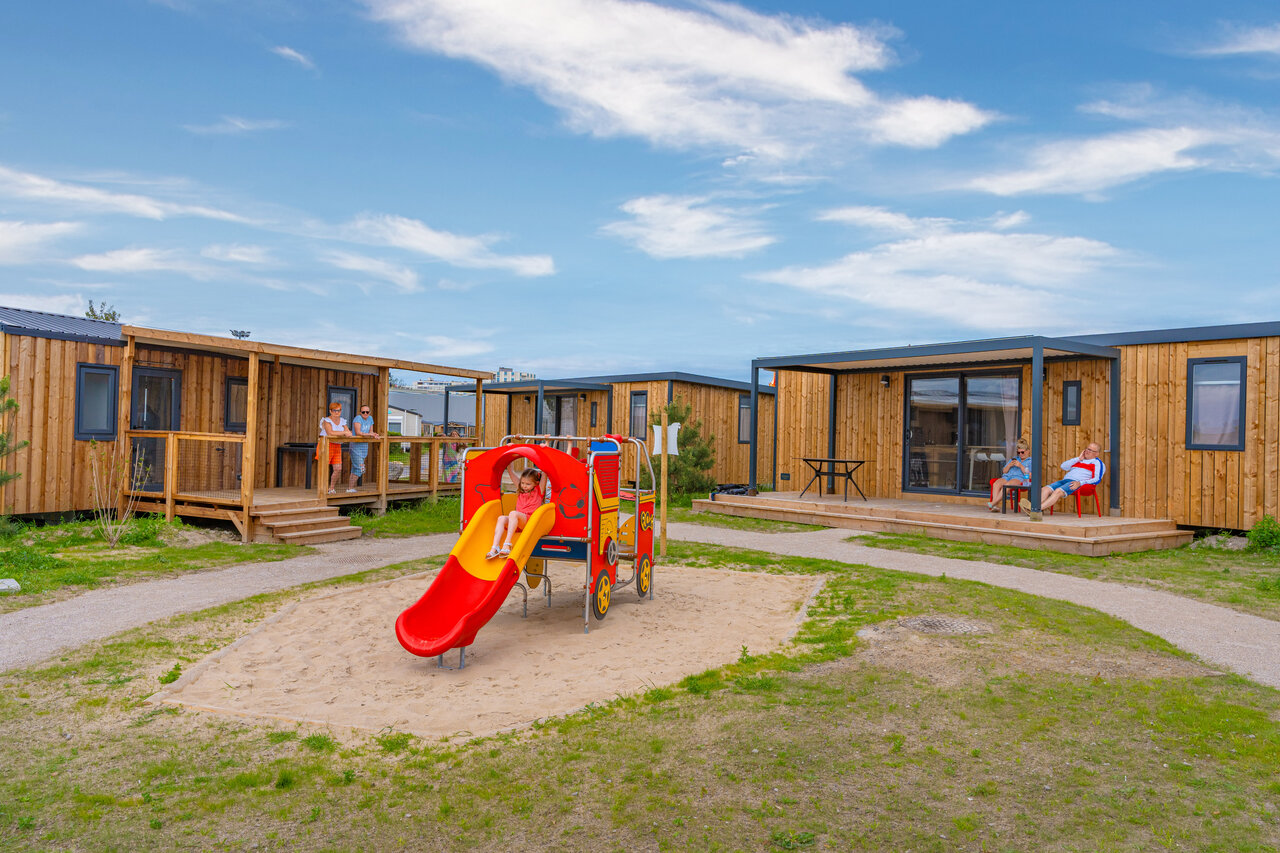 Speeltuin met glijbaan en moderne stacaravans op camping VAGUES OCEANES Licorne in Duinkerke (59).