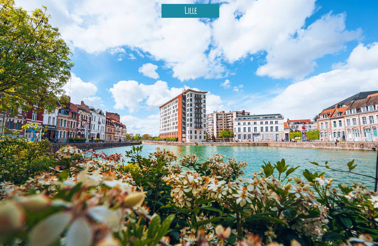 Schilderachtig kanaalzicht in Lille, Hauts-de-France, met historische gebouwen en bloemen.