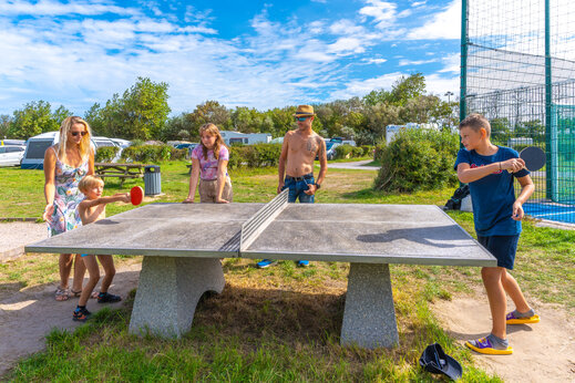 Familie speelt buitentafeltennis op camping VAGUES OCEANES Licorne in Duinkerke (59).