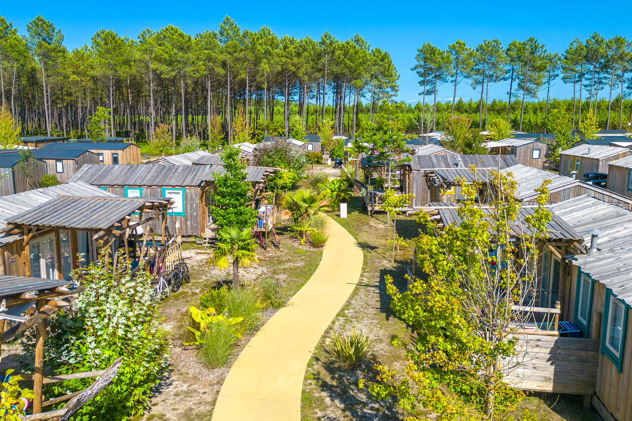 Houten chalets en centraal pad op camping CAPFUN Lila in LINXE (40).