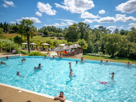 Familie buitenzwembad met zwemmen en waterspellen op camping CLICOCHIC Linotte, Le Bugue.
