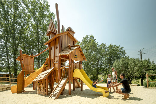 Houten speeltuin met glijbanen voor kinderen op camping CLICOCHIC Linotte.
